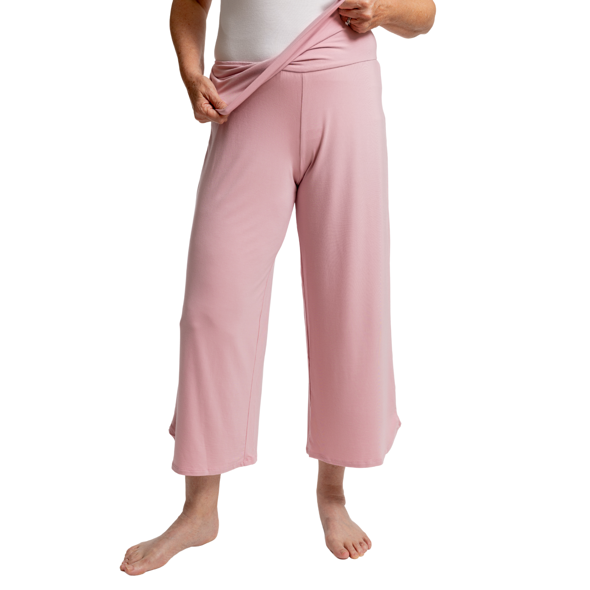 Person wearing pink fold down pants on a white background
